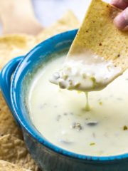 bowl of cheese dip with tortilla dipped in