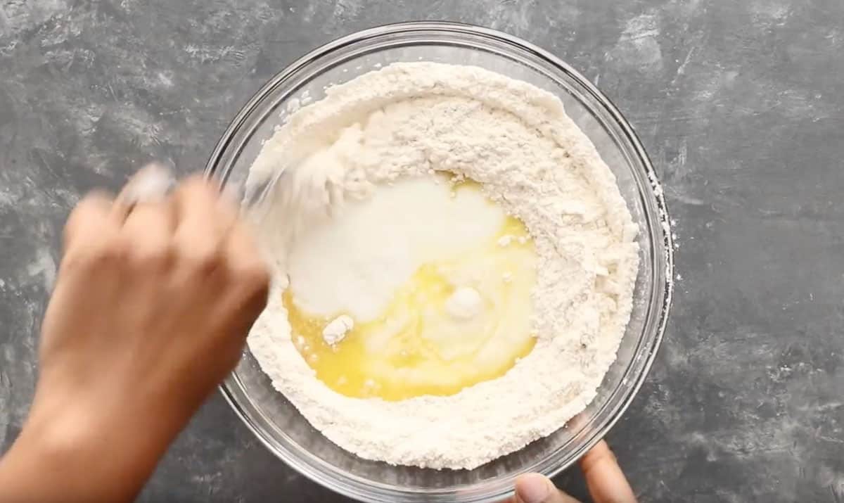 mixing dumpling dough ingredients in glass bowl