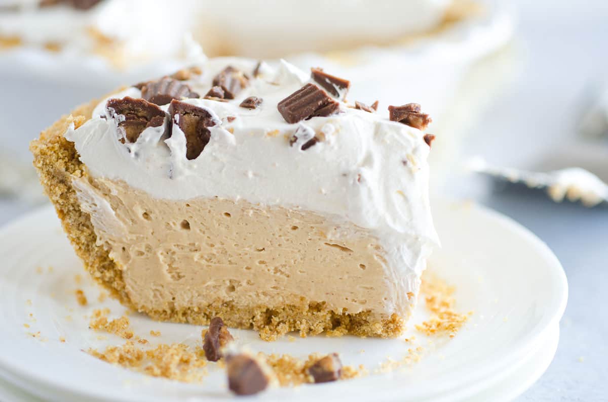 peanut butter pie slice topped with cool whip and chopped peanut butter cups