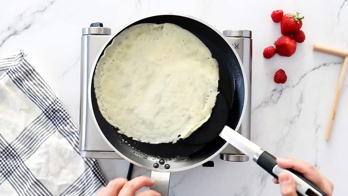 spatula flipping crepe in skillet