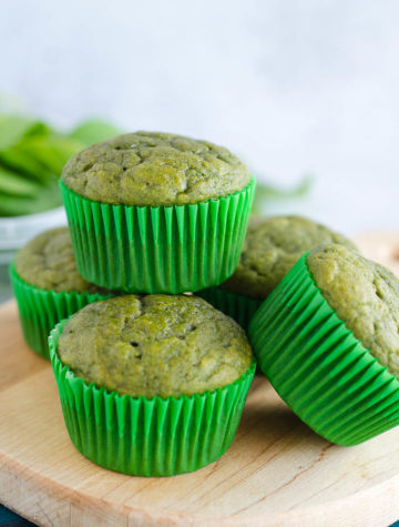 green spinach muffins stacked on cutting board