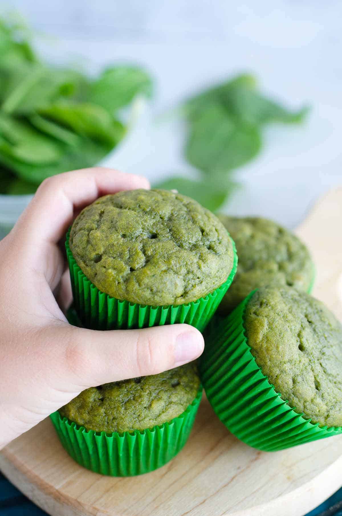 hand grabbing a green muffin