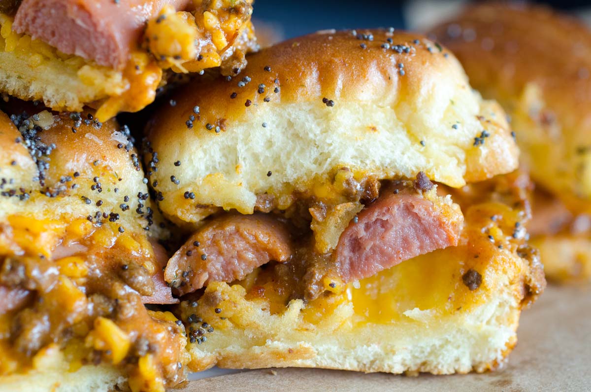 rolls with sliced hot dogs and chili cheese sauce with poppyseed topping