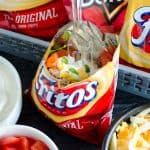 bag of fritos with taco fixins and fork