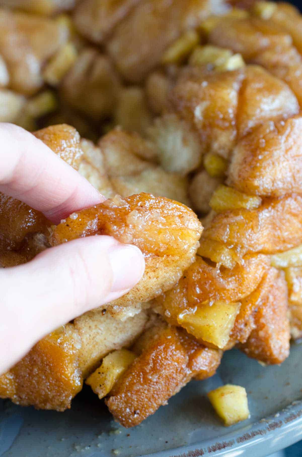 picking a piece out of apple pie monkey bread