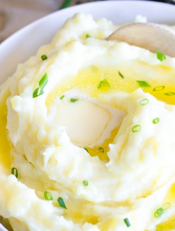 bowl of butter mashed potatoes with wooden spoon