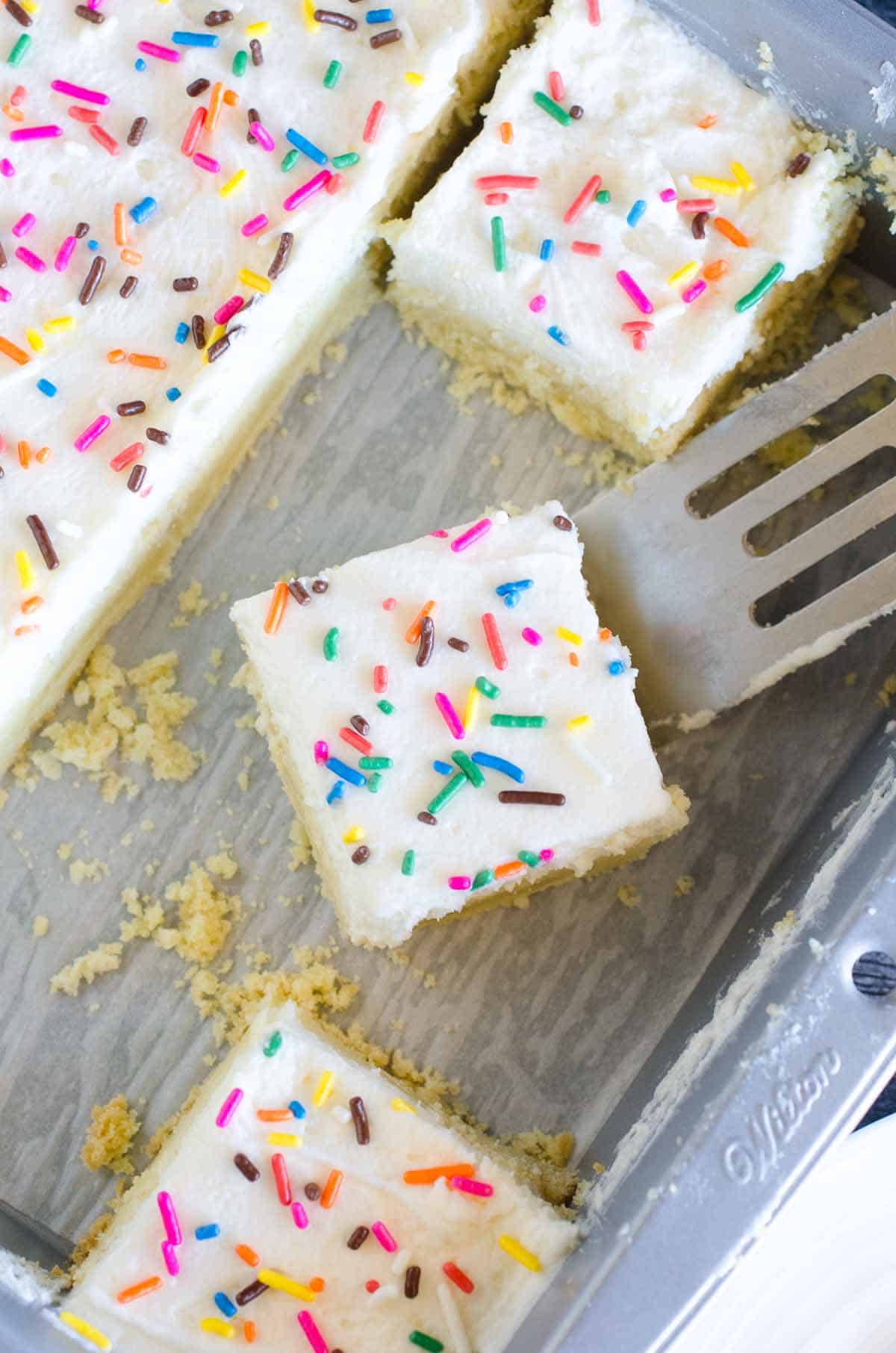 frosted sugar cookie bars with sprinkles in a pan