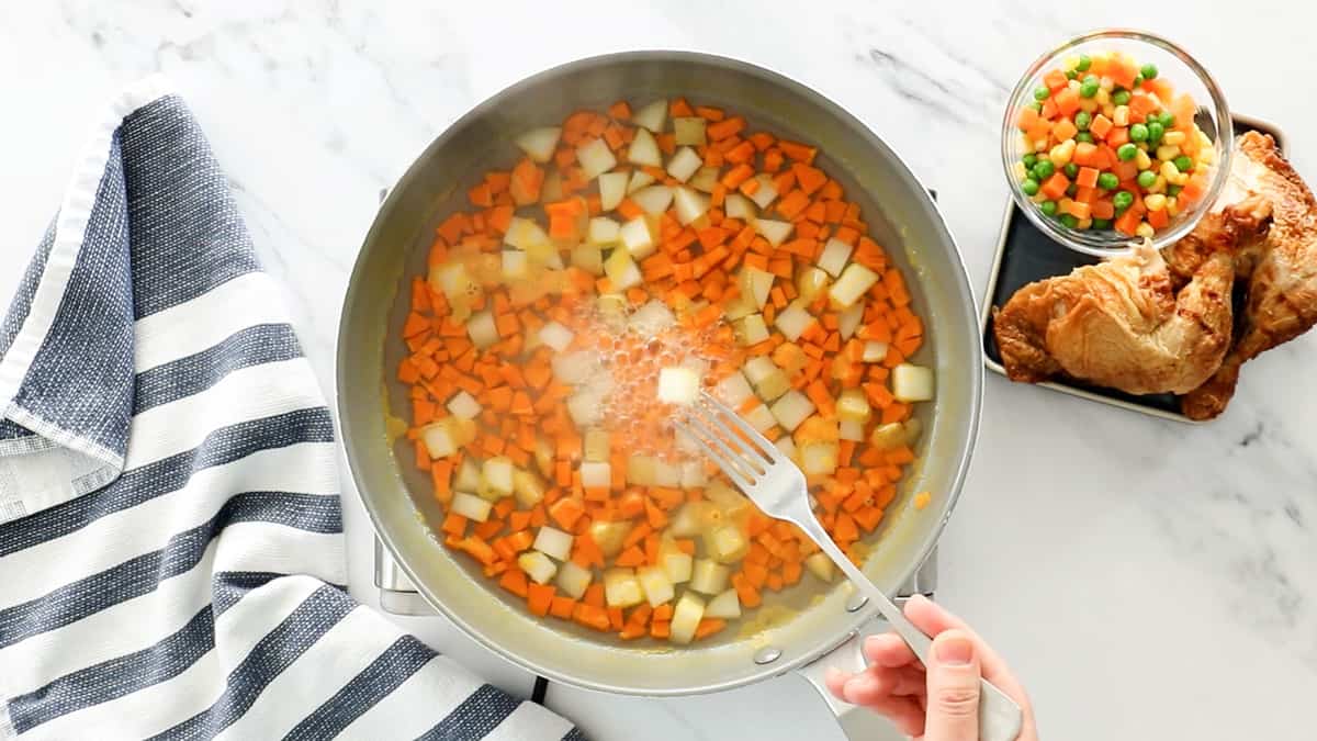 potatoes and carrots cooking in pan of boiling water for pot pie recipe