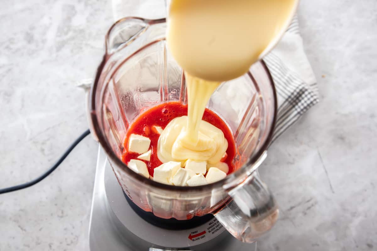 Mixing ingredients in blender for strawberry dessert