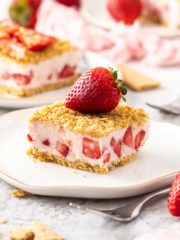 frozen strawberry dessert on a plate topped with a whole strawberry