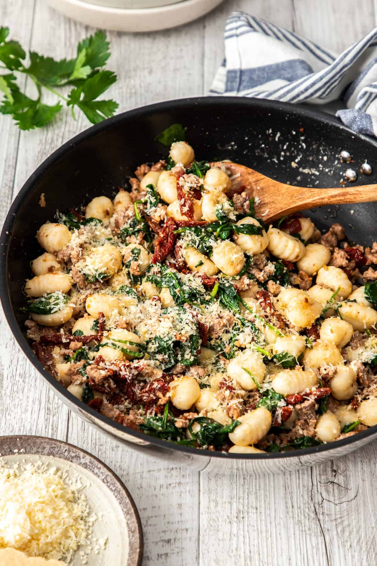 gnocchi in skillet with spinach and sausage and tomatoes