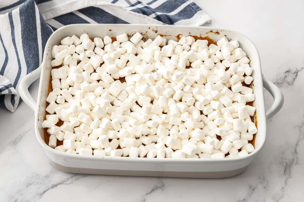 mini marshmallows over top casserole dish with sweet potatoes
