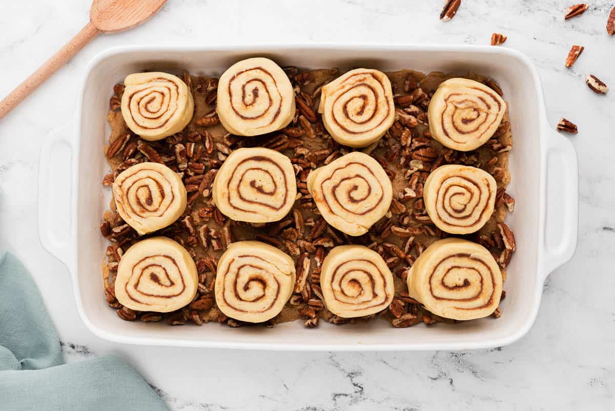 cinnamon roll dough in pan with pecan topping