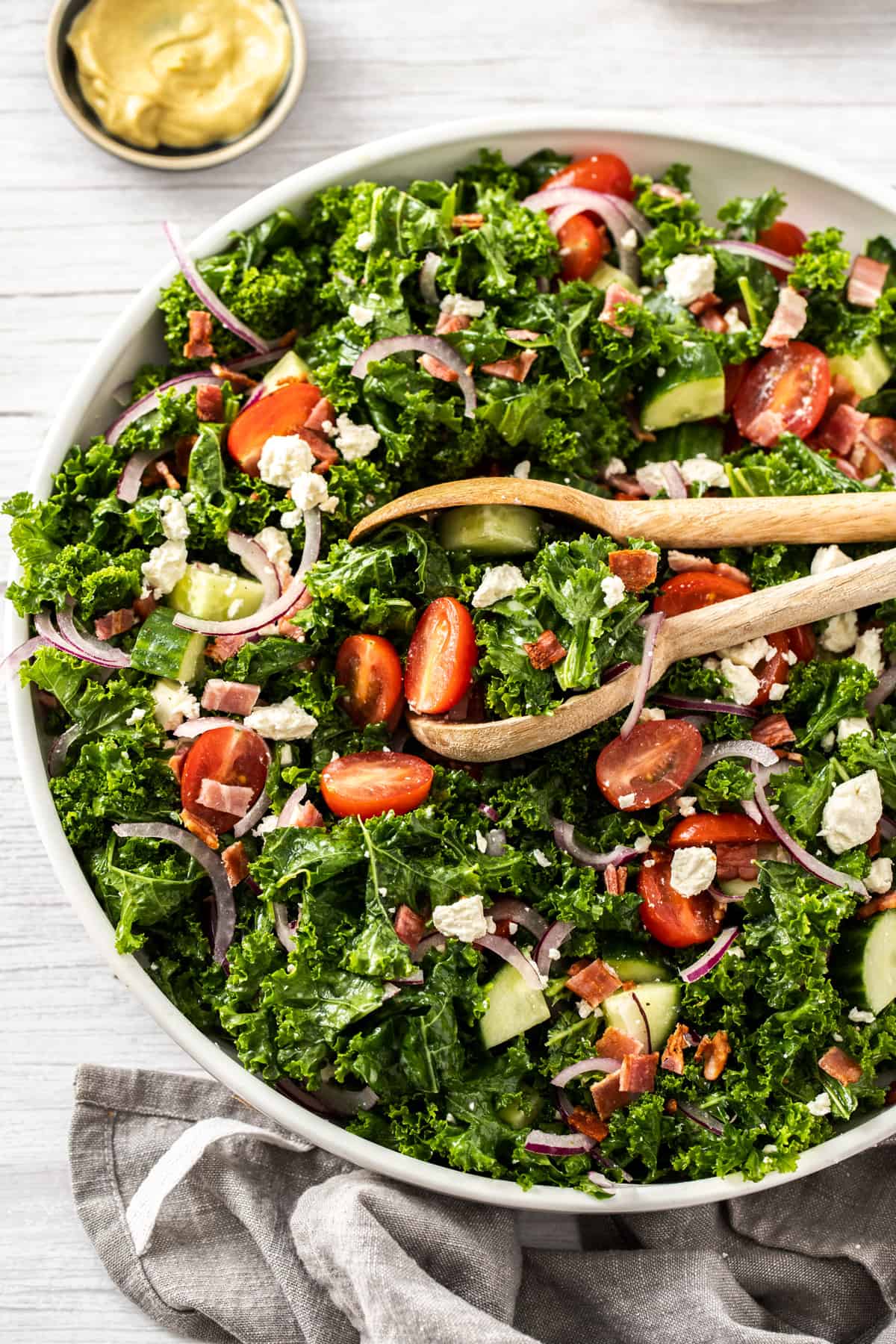 kale salad in a bowl with tongs