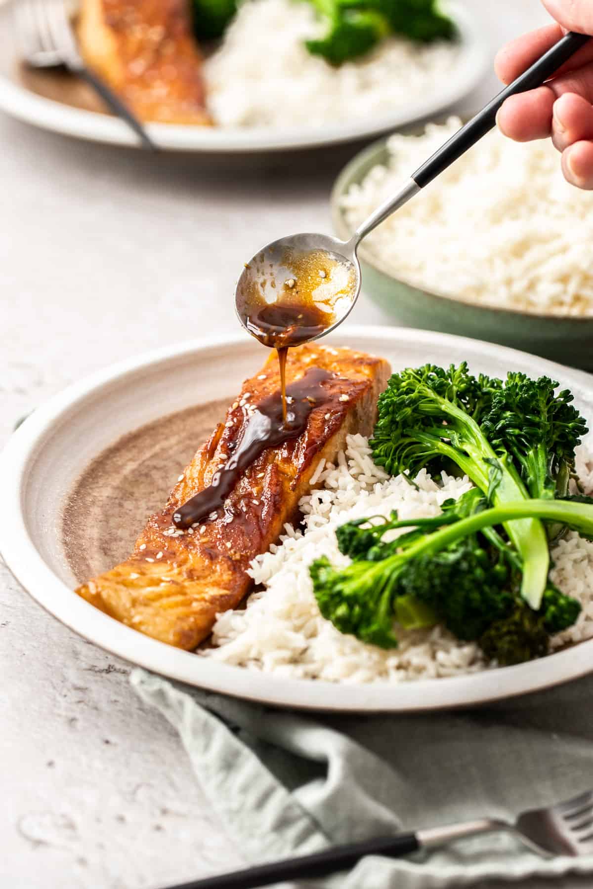plate of glazed salmon with rice and broccolini