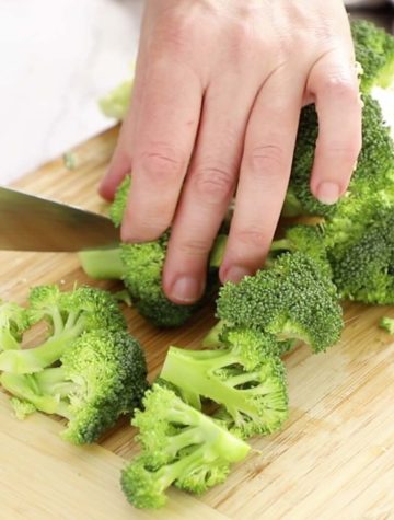 cutting broccoli florets on wooden board