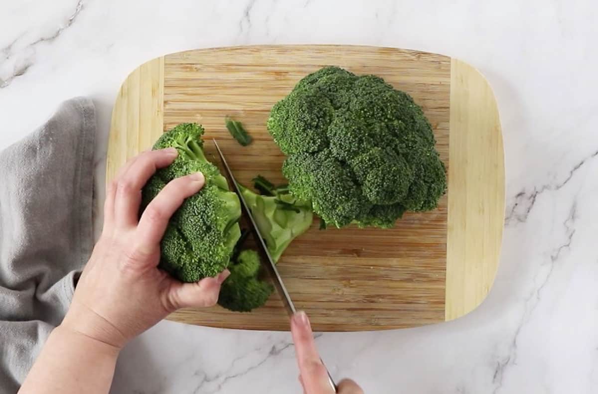 cutting broccoli on wooden cutting board