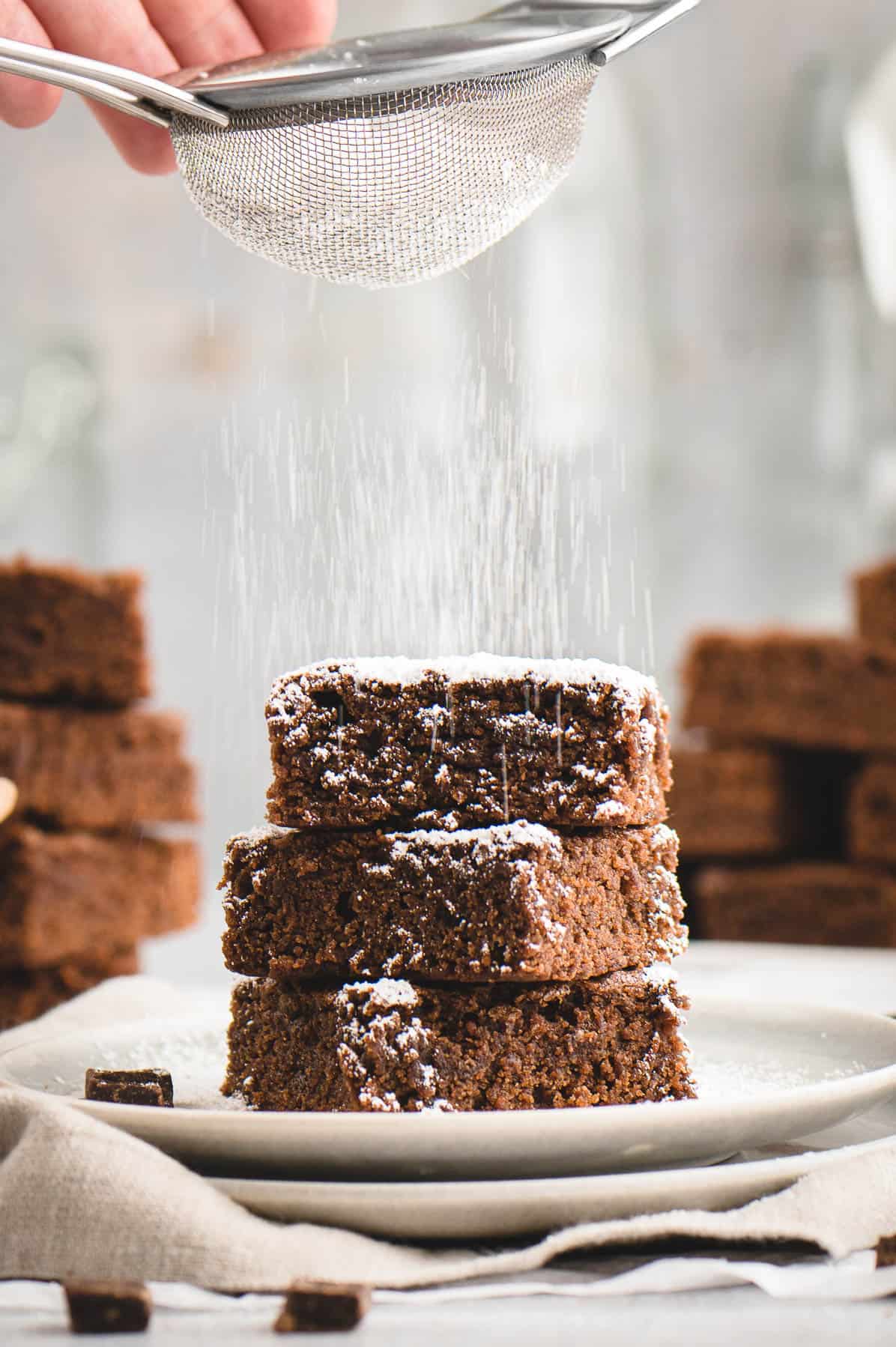 powdered sugar sifted over a stack of brownies