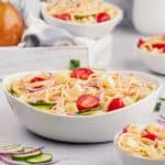 bowl of spaghetti salad with grape tomatoes and cucumbers
