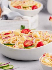 bowl of spaghetti salad with grape tomatoes and cucumbers