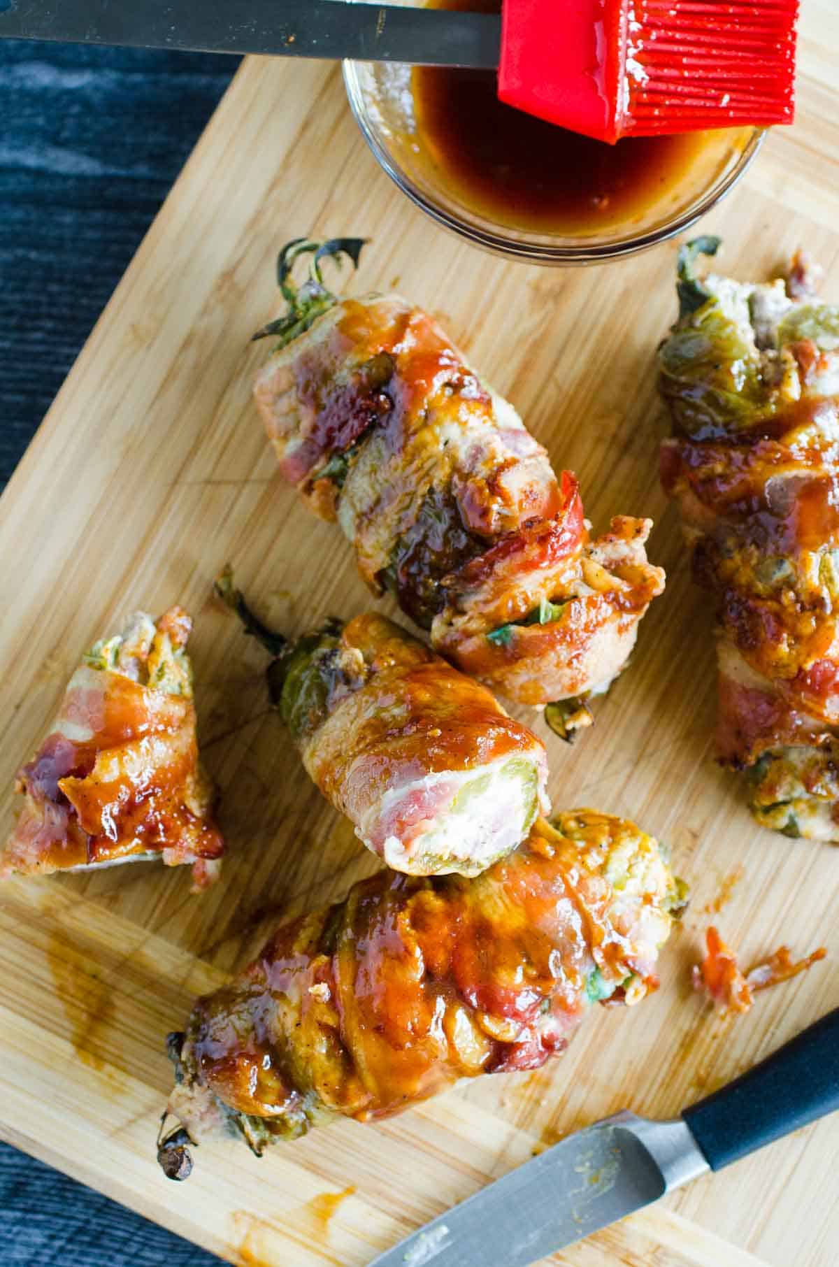 grilled jalapenos wrapped in bacon on a cutting board
