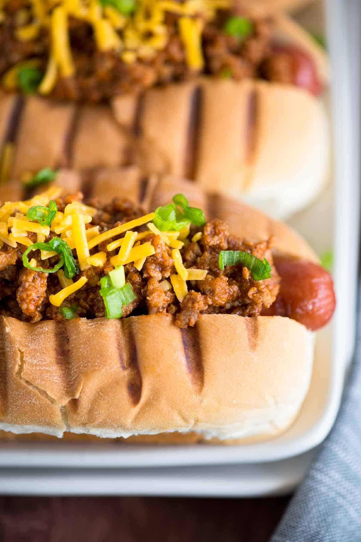 two hot dogs with chili meat sauce and cheese