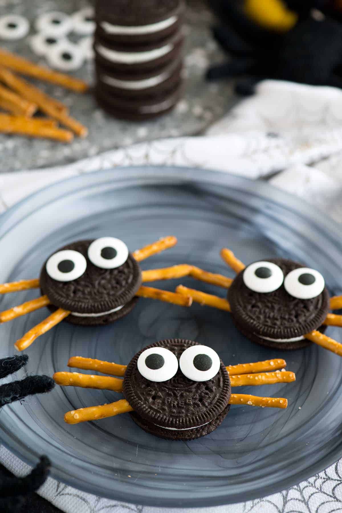 oreo spider cookies on plate with stack of oreo cookies in background