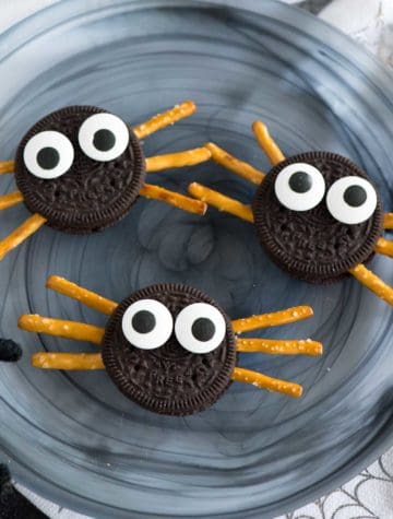oreo cookies with pretzel stick spider legs and candy eyeballs