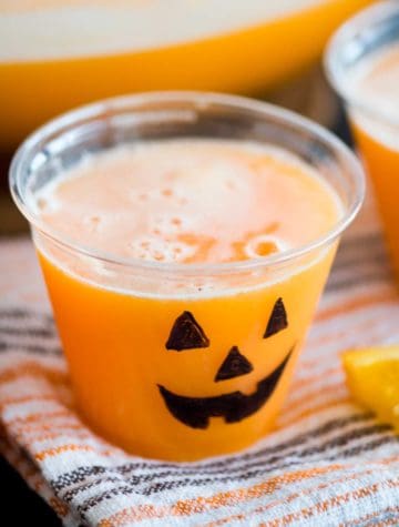 orange punch in a plastic cup with a jack o lantern face