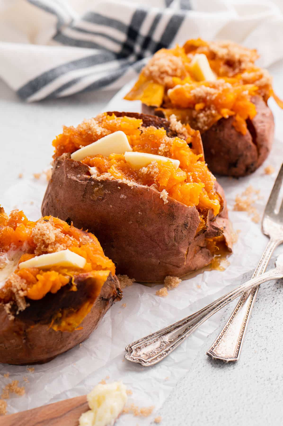 three baked sweet potatoes with butter