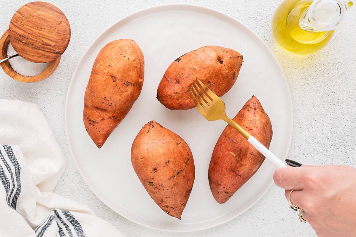 poking holes in skin of sweet potatoes with a fork