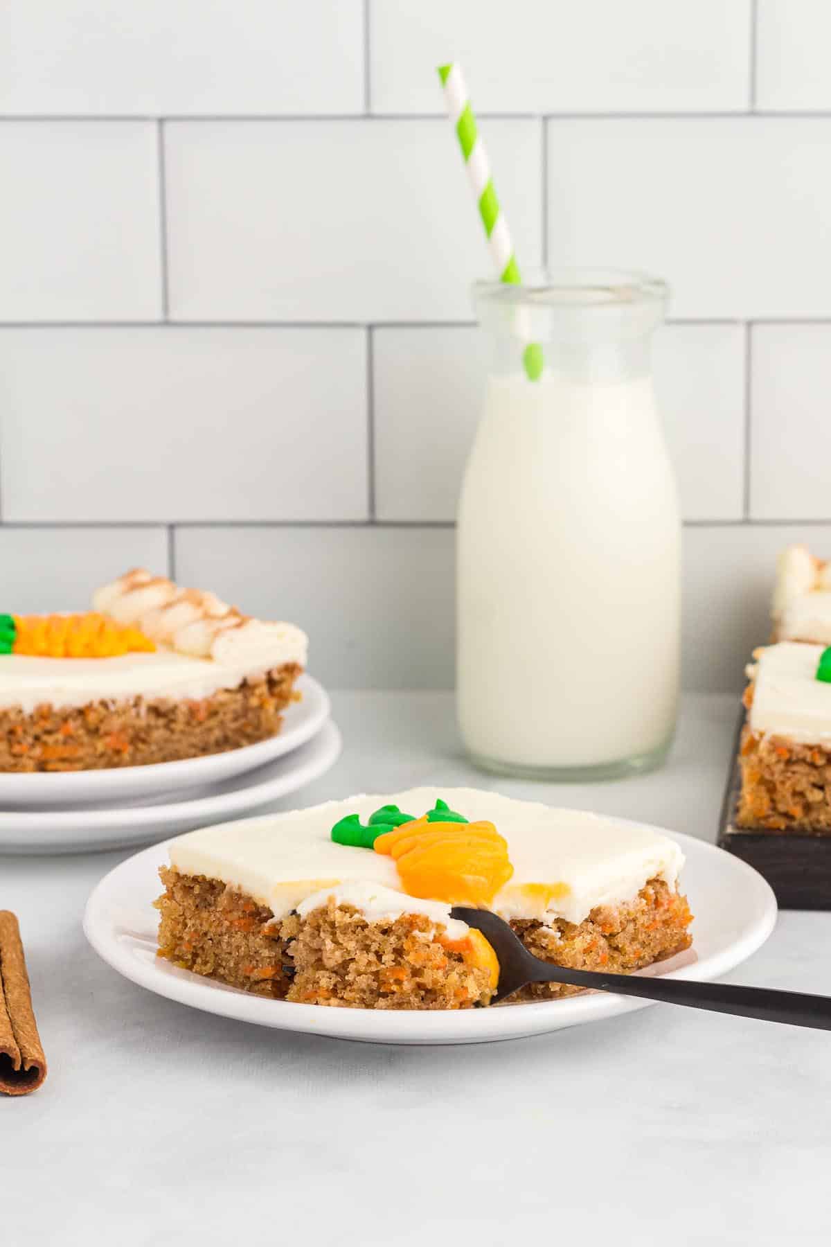 square slice of carrot cake from a sheet pan with a glass of milk