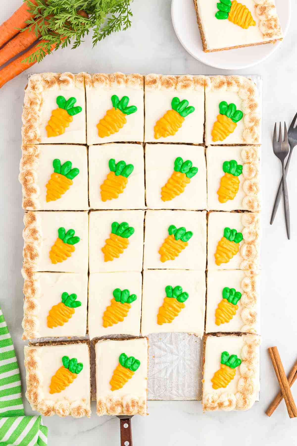 carrot cake made in a sheet pan with cream cheese frosting and decorative carrots