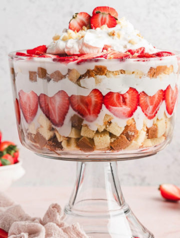 layers of strawberries and cake and cream in a trifle dish