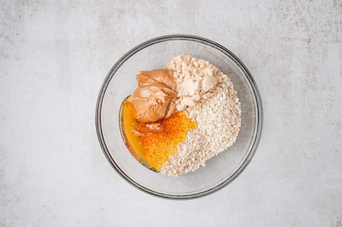 honey and oats and protein powder in a mixing bowl